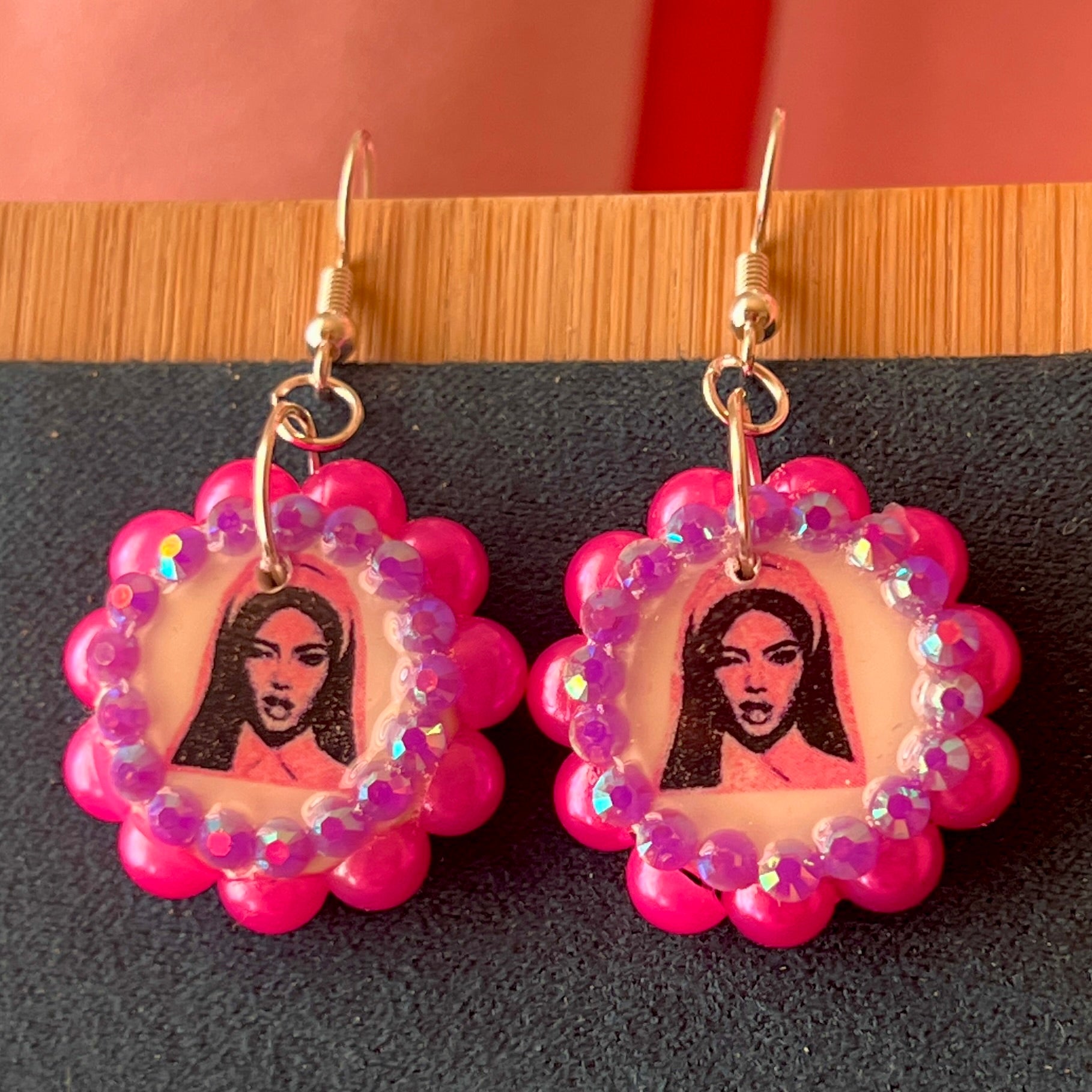 Alt text: Hot pink Y2K nun earrings featuring handmade polymer clay charms bedazzled with iridescent beads, silver plated hypoallergenic hooks, and whimsical gothic, grunge, punk, pink, Y2K style—perfect gift‑ready earrings in a cute green Victorian‑patterned box.