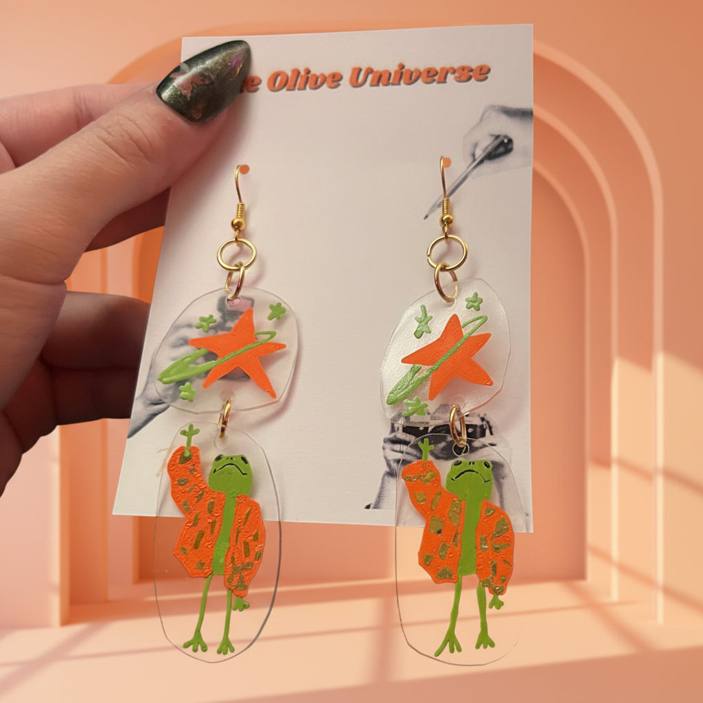 “Reaching for the Star" — Hand-Drawn Cosmic Puffer Frog Earrings