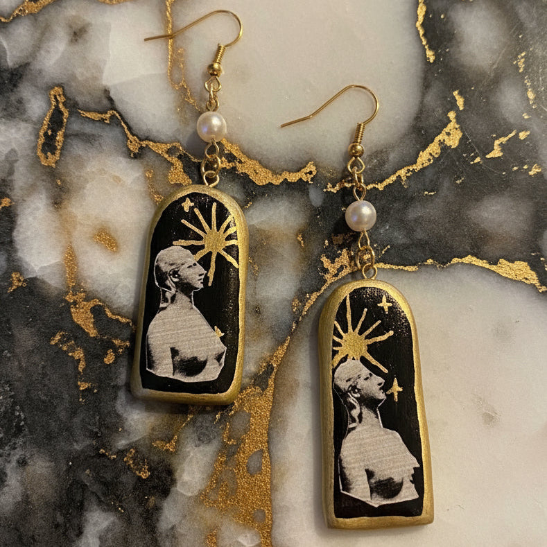 Pair of earrings with artistic design on a dark background