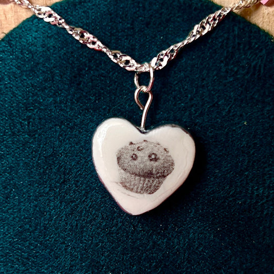 Muffin Man’s Heart blueberry muffin necklace — handmade monochrome polymer clay blueberry muffin charm with metallic silver-black finish on 20" 925 sterling silver chain. Bakerycore snackcore Y2K charm necklace; gift-ready black celestial box. Ships in 1–3 business days.