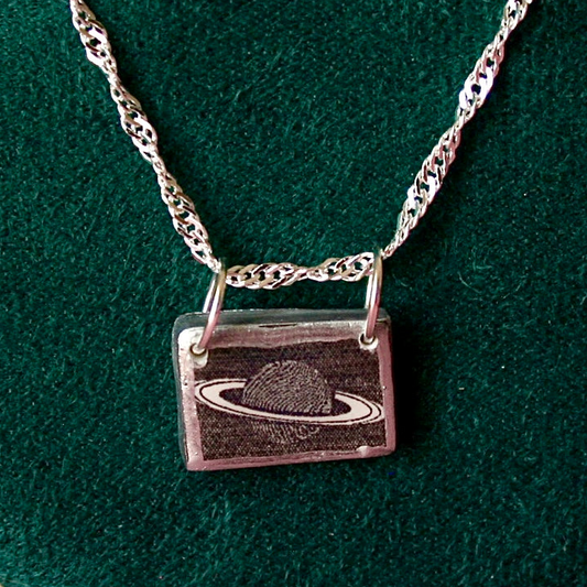 Saturn’s Rings necklace — handmade black & white rectangular polymer clay Saturn charm with metallic silver-black paint on 20" 925 sterling silver chain. Minimal cosmic astrology space jewelry; gift-ready black celestial box. Ready to ship in 1–3 days.