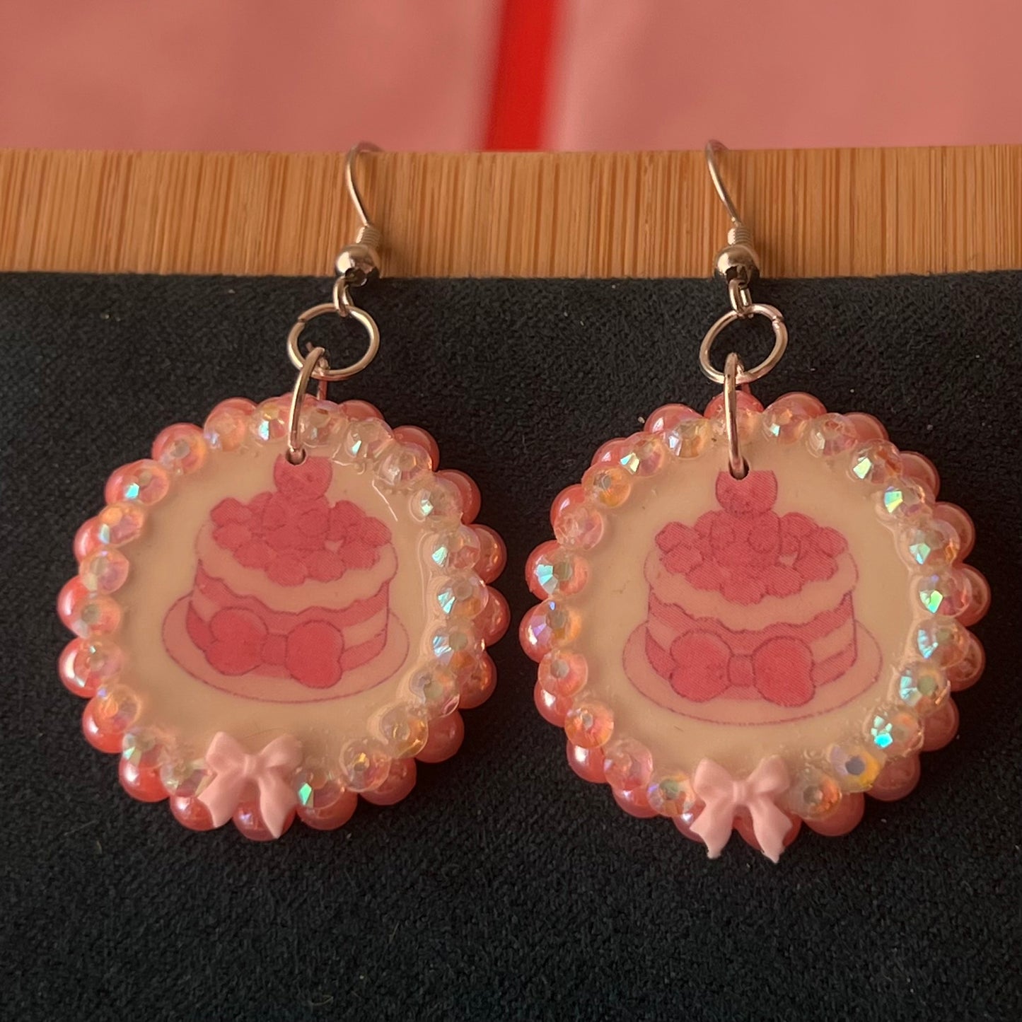 Alt text: Handcrafted polymer‑clay jelly cake earrings with pink coquette bows, iridescent pearls and rhinestones – a sweet, pastel kawaii accessory perfect for a cute dangle look.