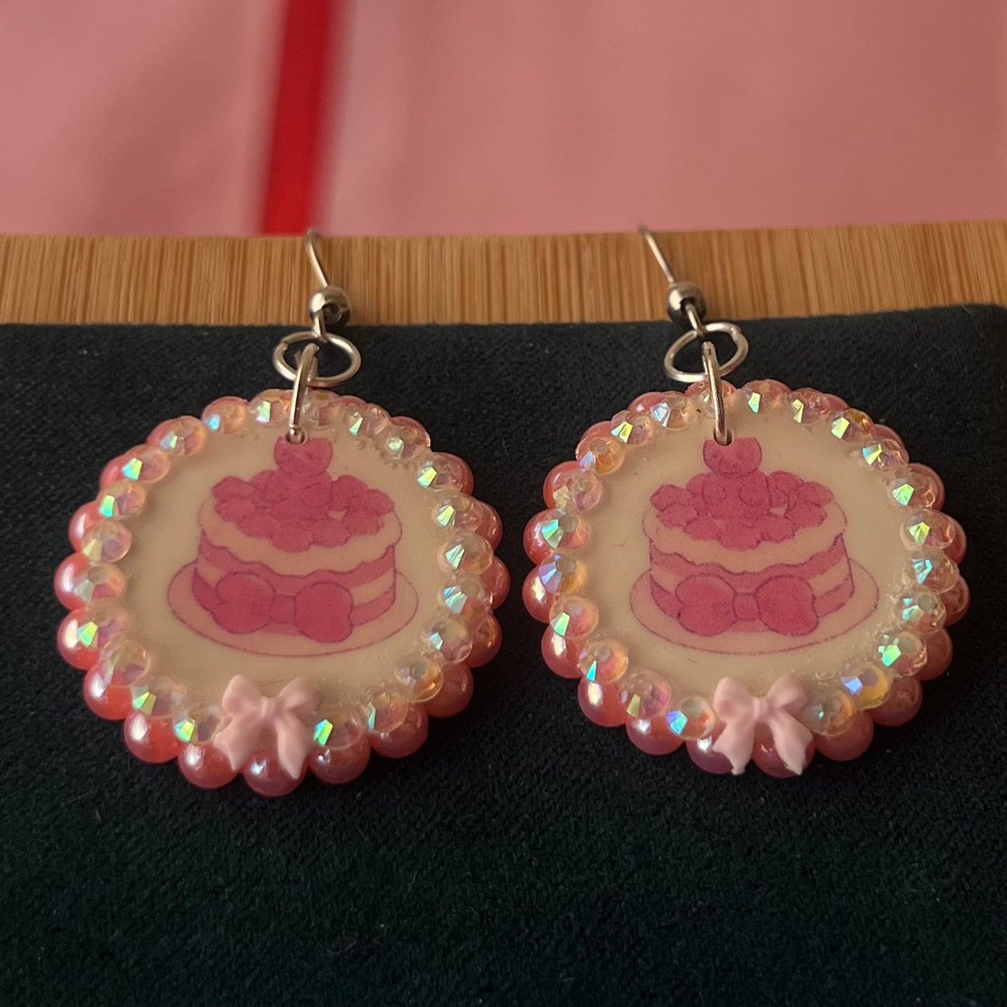 Alt text: Handcrafted polymer‑clay jelly cake earrings with pink coquette bows, iridescent pearls and rhinestones – a sweet, pastel kawaii accessory perfect for a cute dangle look.
