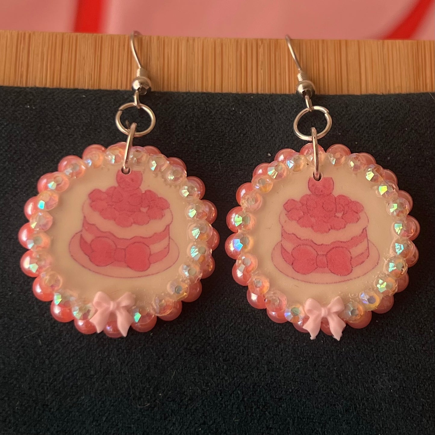 Alt text: Handcrafted polymer‑clay jelly cake earrings with pink coquette bows, iridescent pearls and rhinestones – a sweet, pastel kawaii accessory perfect for a cute dangle look.