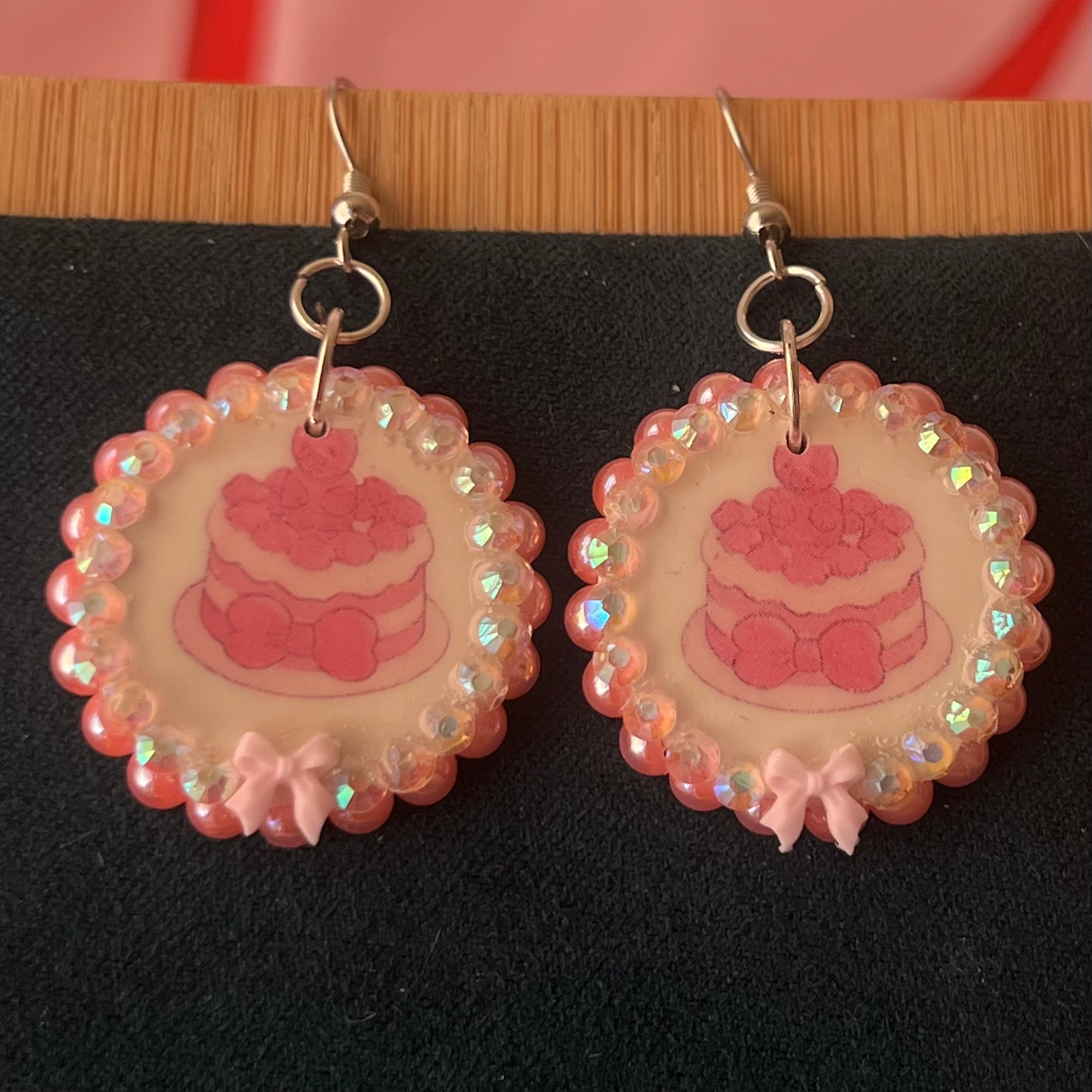 Alt text: Handcrafted polymer‑clay jelly cake earrings with pink coquette bows, iridescent pearls and rhinestones – a sweet, pastel kawaii accessory perfect for a cute dangle look.