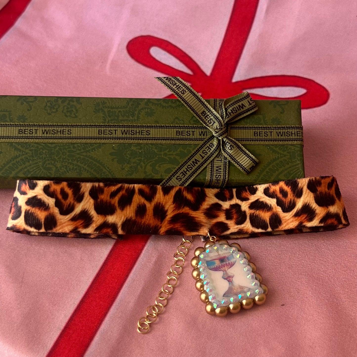 Jungle Elixir choker — soft cheetah print choker with handmade polymer clay fantasy chalice charm framed with bronze pearls and iridescent rhinestones. Adjustable fit ~14–16" with extension chain. Gift-ready green Victorian-patterned box + bow. Ready to ship in 1–3 days.