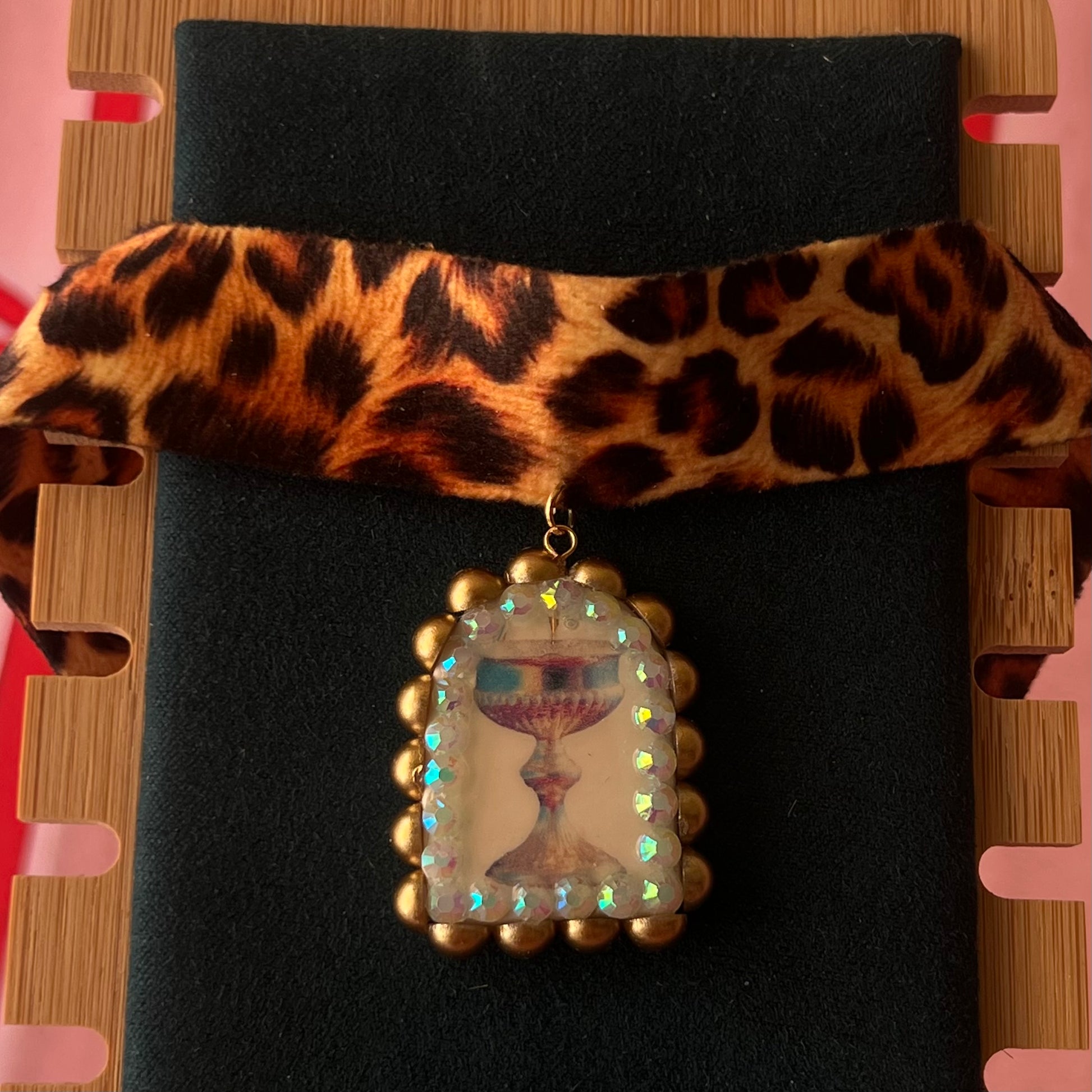 Jungle Elixir choker — soft cheetah print choker with handmade polymer clay fantasy chalice charm framed with bronze pearls and iridescent rhinestones. Adjustable fit ~14–16" with extension chain. Gift-ready green Victorian-patterned box + bow. Ready to ship in 1–3 days.