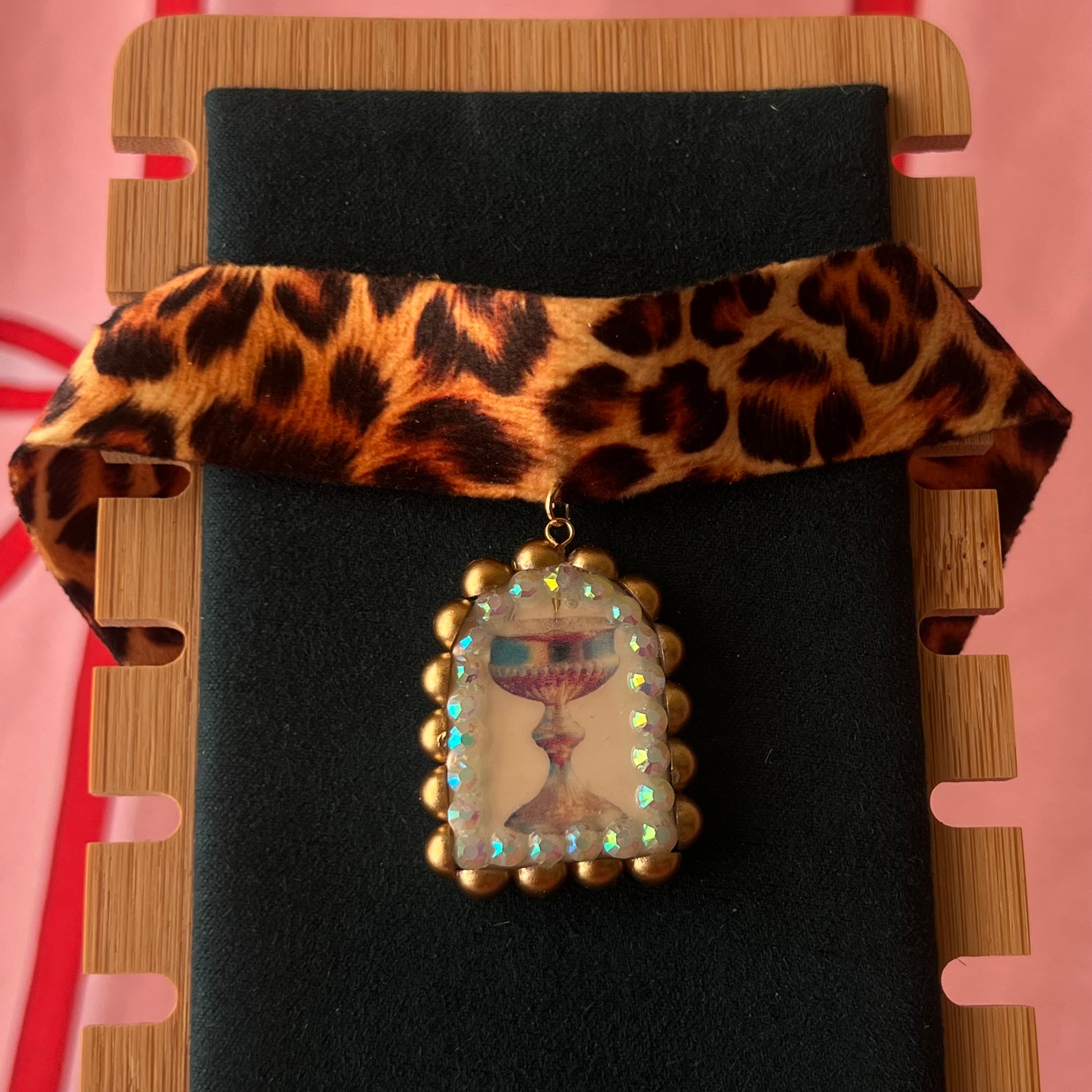 Jungle Elixir choker — soft cheetah print choker with handmade polymer clay fantasy chalice charm framed with bronze pearls and iridescent rhinestones. Adjustable fit ~14–16" with extension chain. Gift-ready green Victorian-patterned box + bow. Ready to ship in 1–3 days.