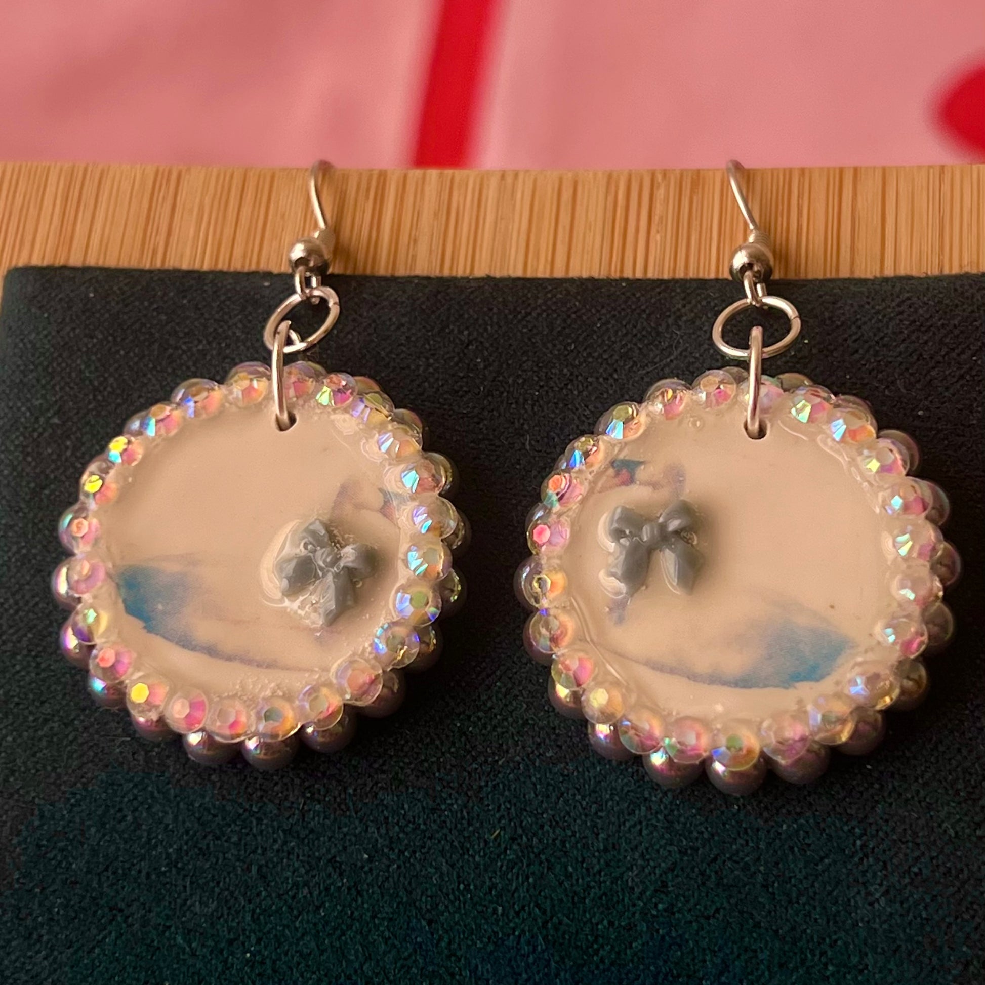 Handcrafted polymer‑clay “kissing swans” earrings with coquette pink bow ties, iridescent pearls, rhinestones, and hypoallergenic 18k gold‑plated findings – a pastel, kawaii, sweet‑lolita, y2k‑style romantic accessory.