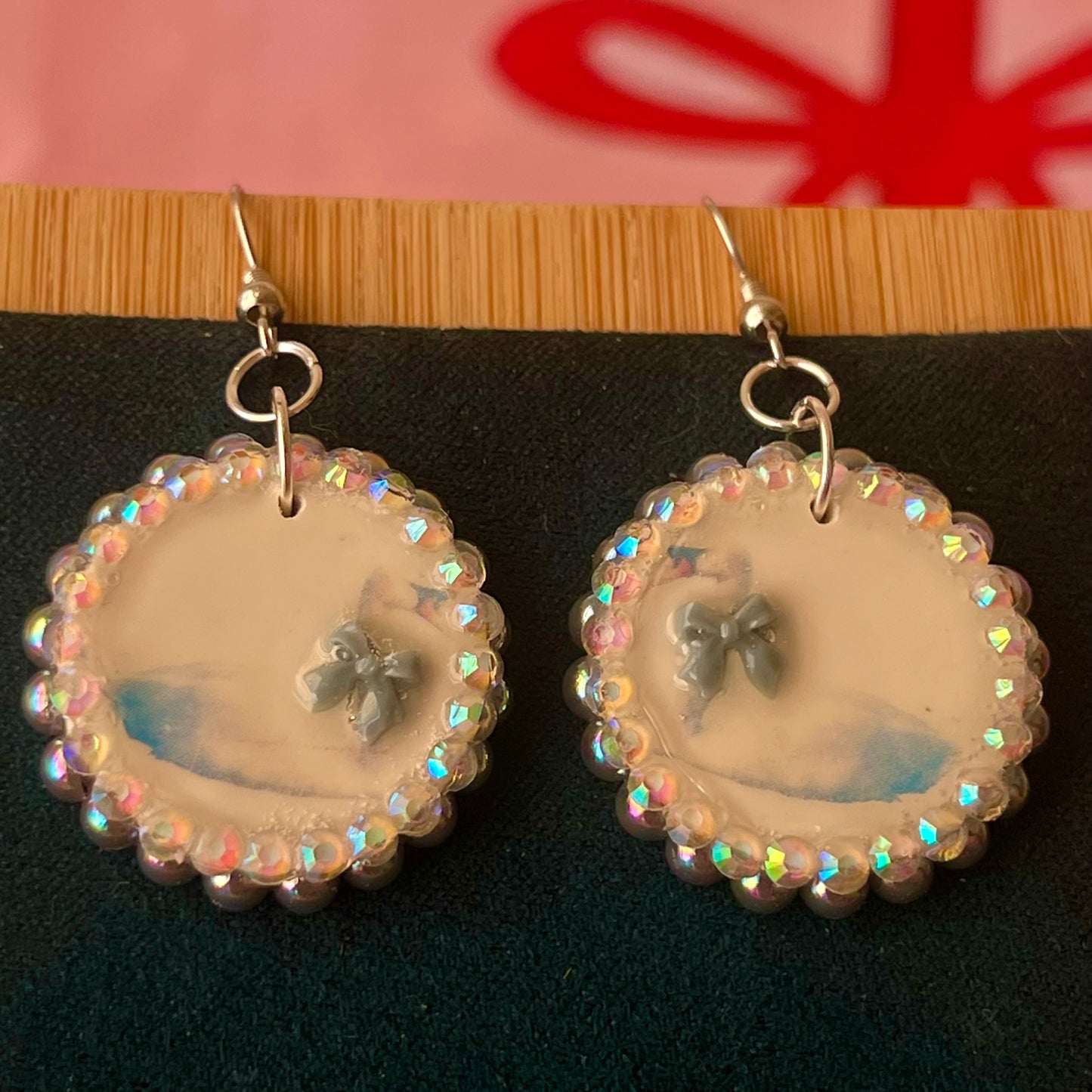 Handcrafted polymer‑clay “kissing swans” earrings with coquette pink bow ties, iridescent pearls, rhinestones, and hypoallergenic 18k gold‑plated findings – a pastel, kawaii, sweet‑lolita, y2k‑style romantic accessory.