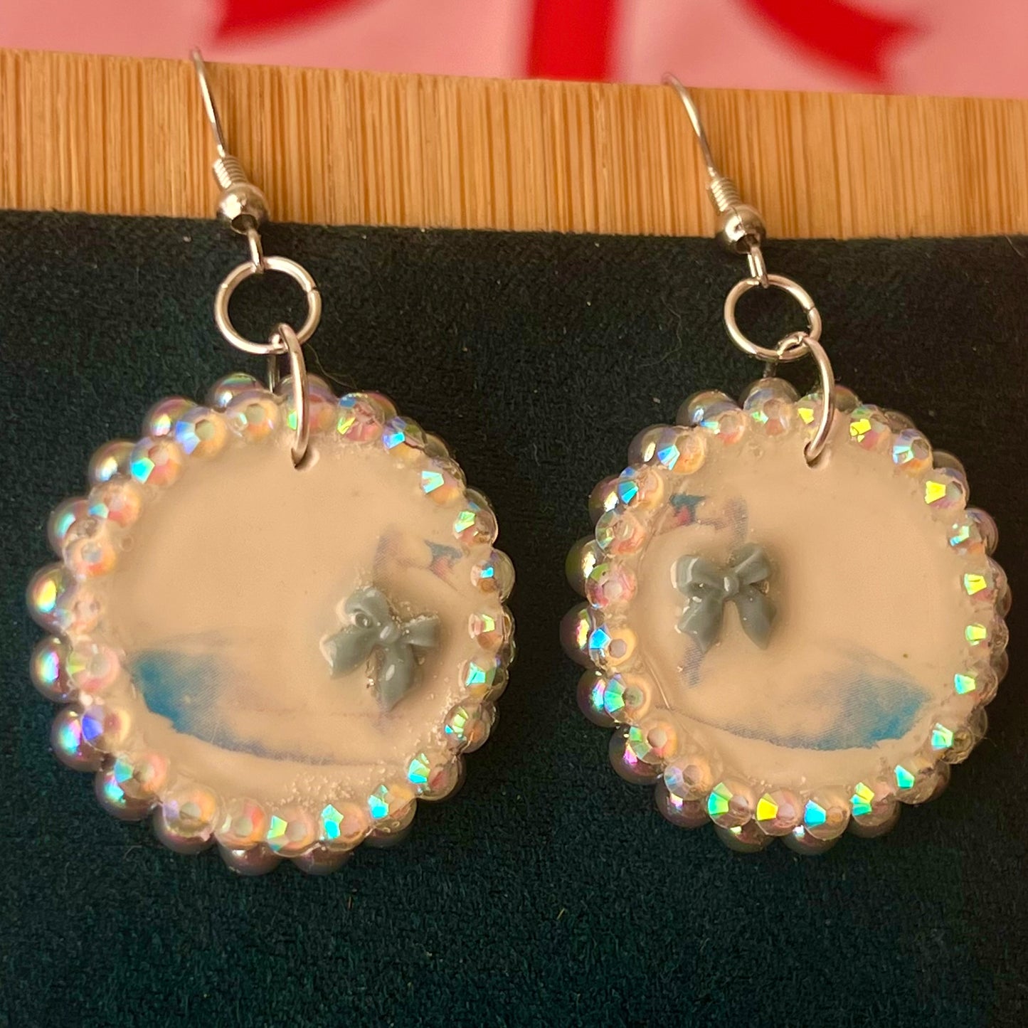 Handcrafted polymer‑clay “kissing swans” earrings with coquette pink bow ties, iridescent pearls, rhinestones, and hypoallergenic 18k gold‑plated findings – a pastel, kawaii, sweet‑lolita, y2k‑style romantic accessory.