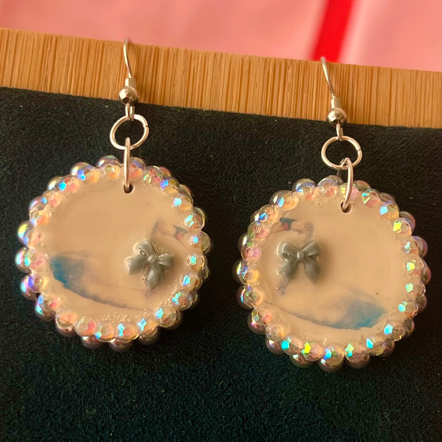 Handcrafted polymer‑clay “kissing swans” earrings with coquette pink bow ties, iridescent pearls, rhinestones, and hypoallergenic 18k gold‑plated findings – a pastel, kawaii, sweet‑lolita, y2k‑style romantic accessory.