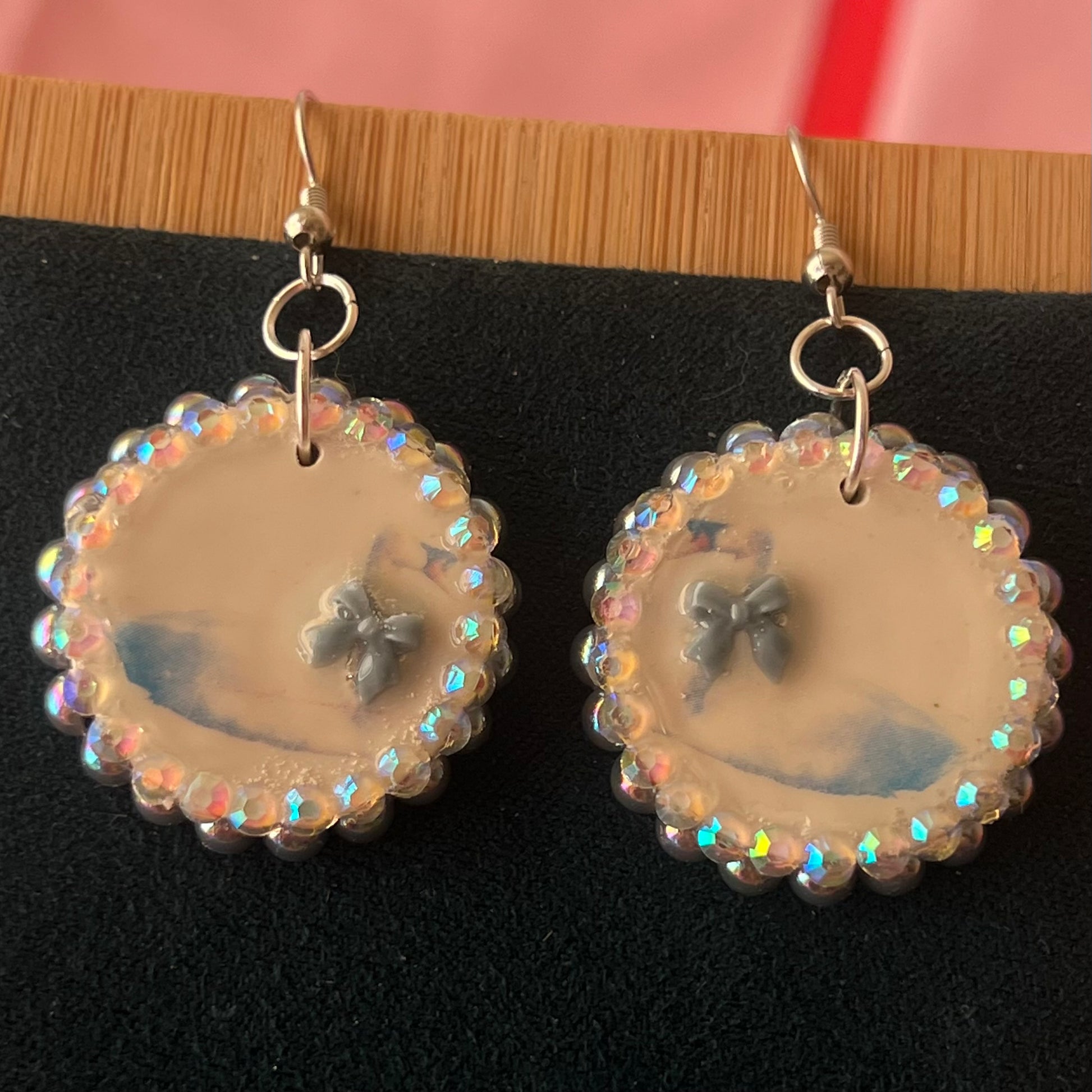 Handcrafted polymer‑clay “kissing swans” earrings with coquette pink bow ties, iridescent pearls, rhinestones, and hypoallergenic 18k gold‑plated findings – a pastel, kawaii, sweet‑lolita, y2k‑style romantic accessory.