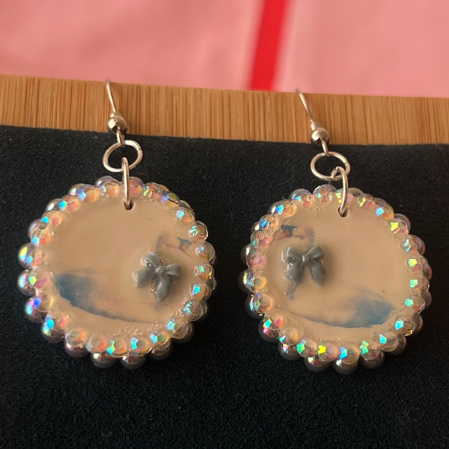 Handcrafted polymer‑clay “kissing swans” earrings with coquette pink bow ties, iridescent pearls, rhinestones, and hypoallergenic 18k gold‑plated findings – a pastel, kawaii, sweet‑lolita, y2k‑style romantic accessory.