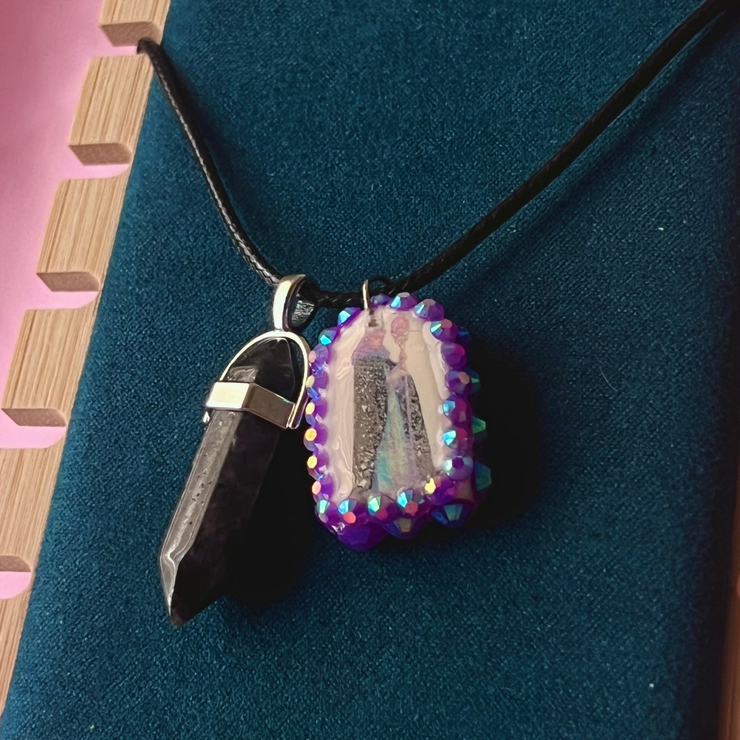 Medieval sorceress polymer charm necklace — black vegan leather chain with black marbled stone pendant plus arched sorceress charm (approx. 1" x 0.75") featuring staff + glowing orb, bedazzled with purple iridescent pearls. Dark medievalcore / fantasy talisman jewelry; ready to ship.