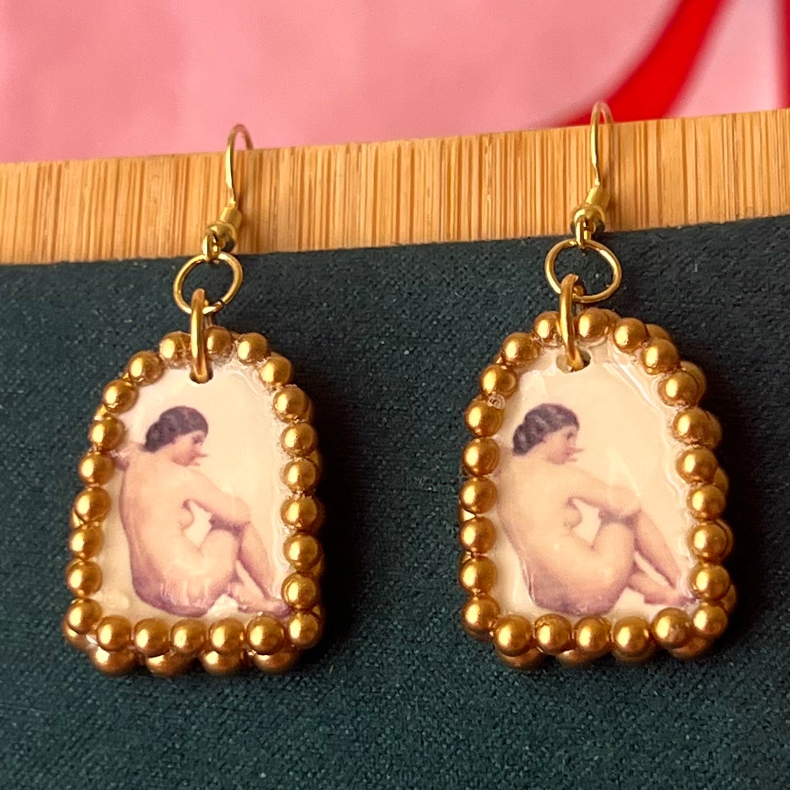 Handmade nude lady earrings featuring bronze polymer‑clay arch charms with an oil‑painting‑style image transfer and a sparkling pearl frame, set on 18k gold‑plated, hypoallergenic findings—perfect museum‑core, renaissance, medieval, coquette, and fairycore jewelry.