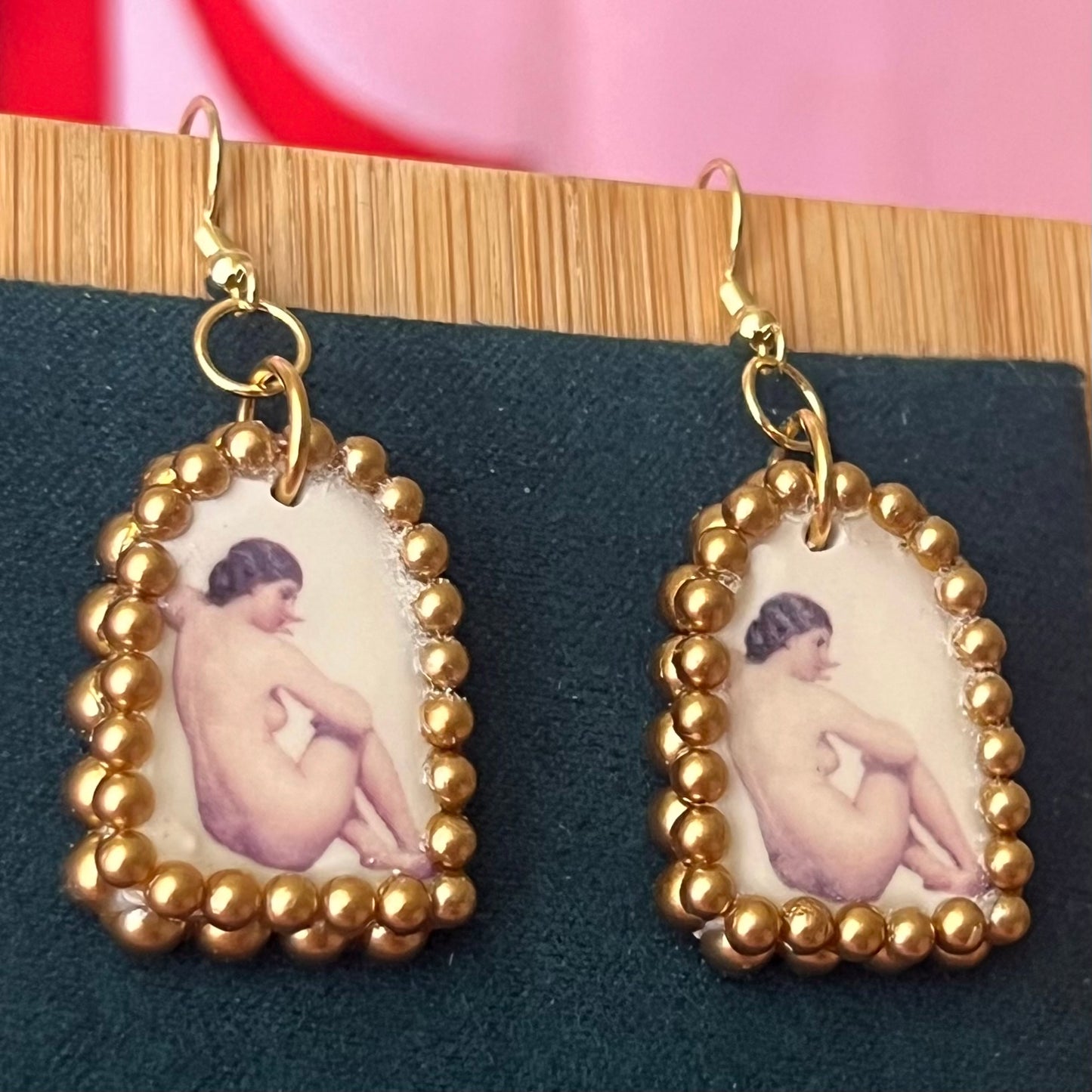 Handmade nude lady earrings featuring bronze polymer‑clay arch charms with an oil‑painting‑style image transfer and a sparkling pearl frame, set on 18k gold‑plated, hypoallergenic findings—perfect museum‑core, renaissance, medieval, coquette, and fairycore jewelry.