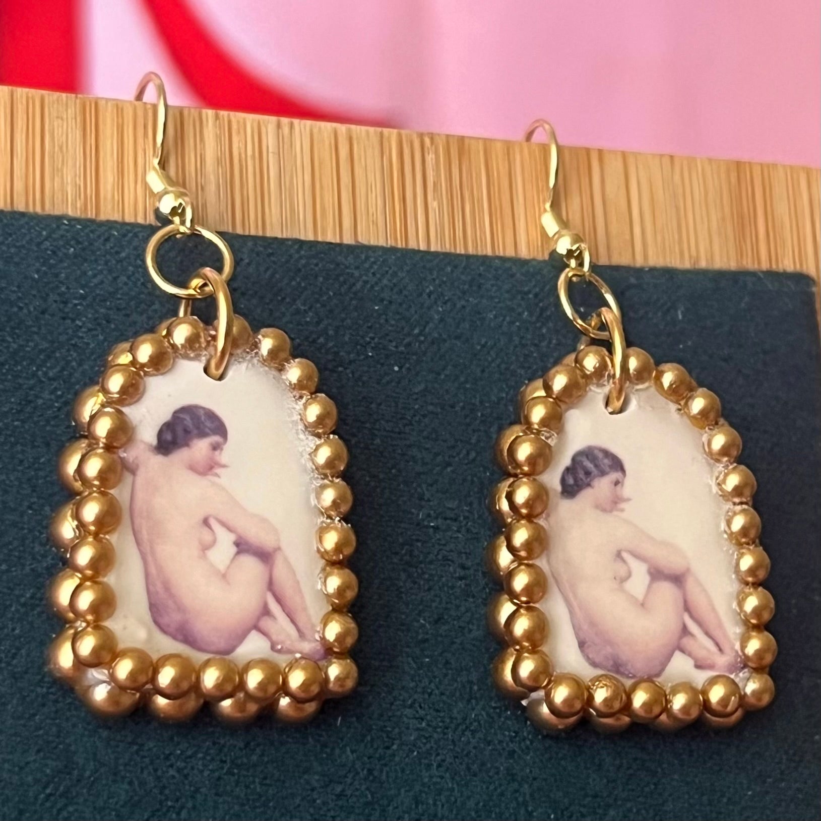 Handmade nude lady earrings featuring bronze polymer‑clay arch charms with an oil‑painting‑style image transfer and a sparkling pearl frame, set on 18k gold‑plated, hypoallergenic findings—perfect museum‑core, renaissance, medieval, coquette, and fairycore jewelry.