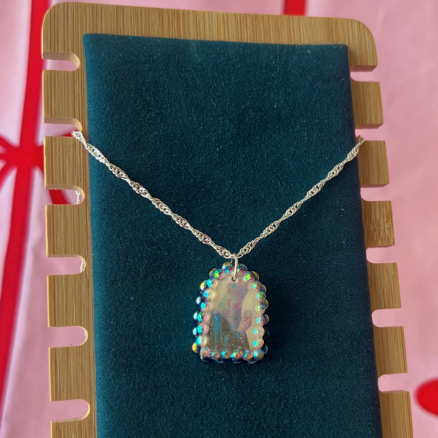 Oracle elf necklace — handmade polymer clay medieval-inspired divination elf charm (approx. 1") with iridescent finish, bedazzled with iridescent black pearls + rhinestones on 20" 925 sterling silver chain. Gift-ready Victorian-patterned box with green bow. Ready to ship in 1–3 business days.