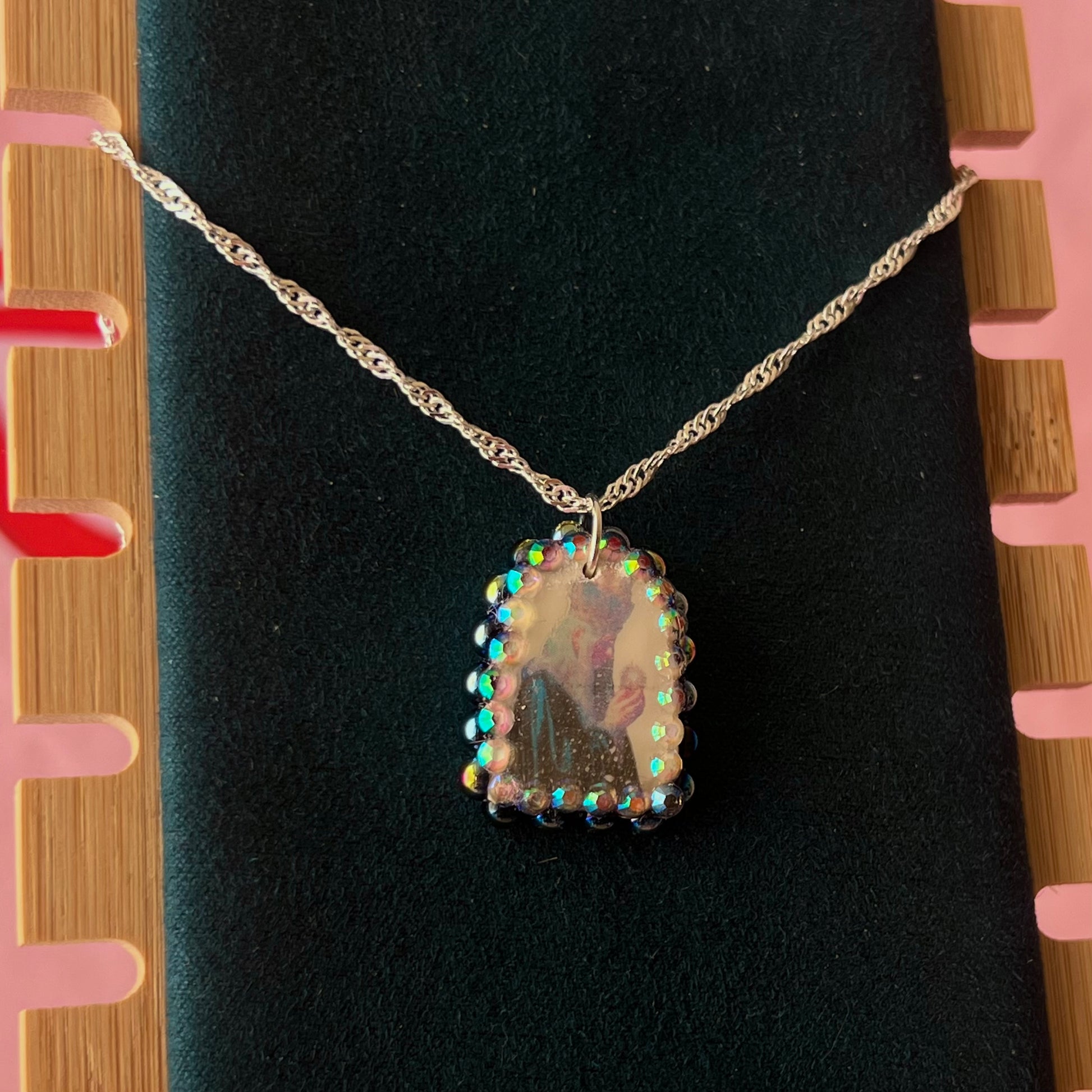 Oracle elf necklace — handmade polymer clay medieval-inspired divination elf charm (approx. 1") with iridescent finish, bedazzled with iridescent black pearls + rhinestones on 20" 925 sterling silver chain. Gift-ready Victorian-patterned box with green bow. Ready to ship in 1–3 business days.