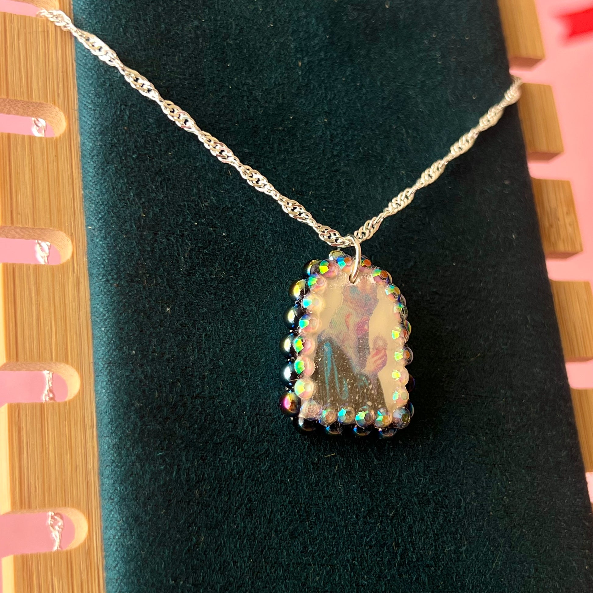 Oracle elf necklace — handmade polymer clay medieval-inspired divination elf charm (approx. 1") with iridescent finish, bedazzled with iridescent black pearls + rhinestones on 20" 925 sterling silver chain. Gift-ready Victorian-patterned box with green bow. Ready to ship in 1–3 business days.