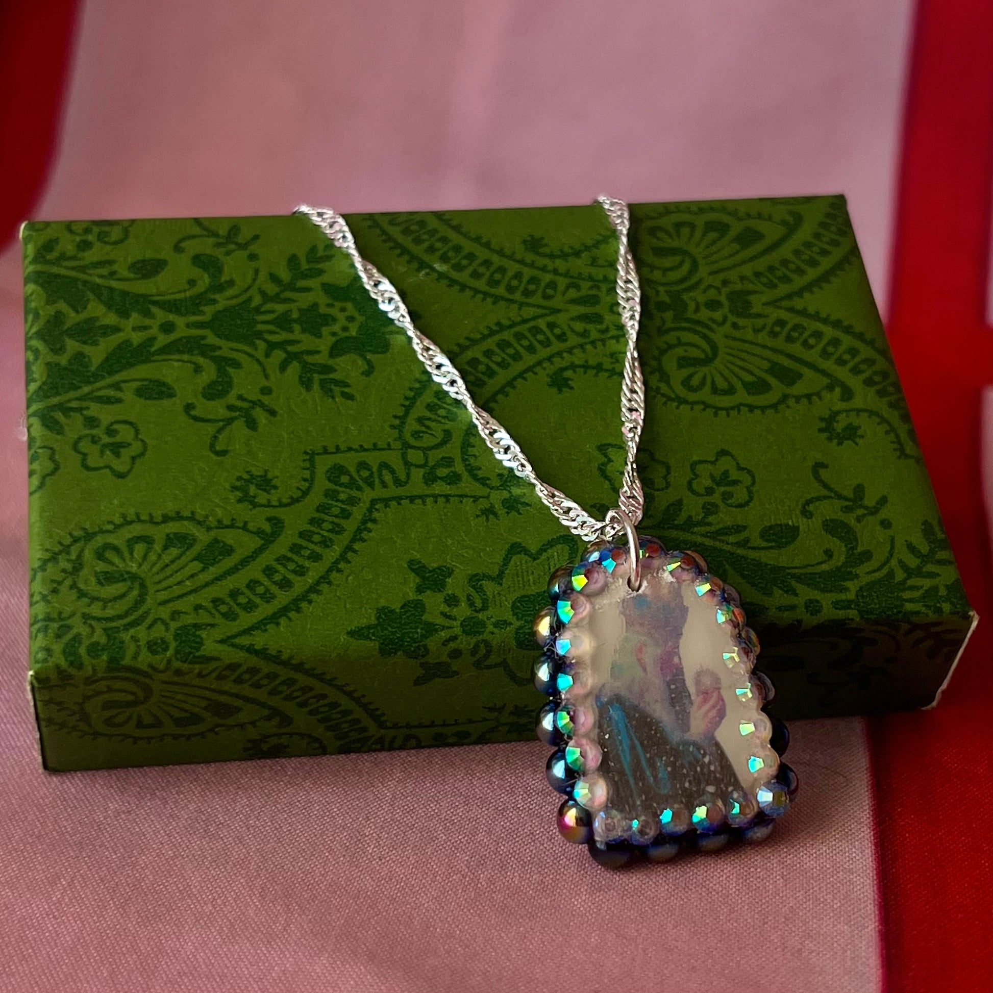 Oracle elf necklace — handmade polymer clay medieval-inspired divination elf charm (approx. 1") with iridescent finish, bedazzled with iridescent black pearls + rhinestones on 20" 925 sterling silver chain. Gift-ready Victorian-patterned box with green bow. Ready to ship in 1–3 business days.