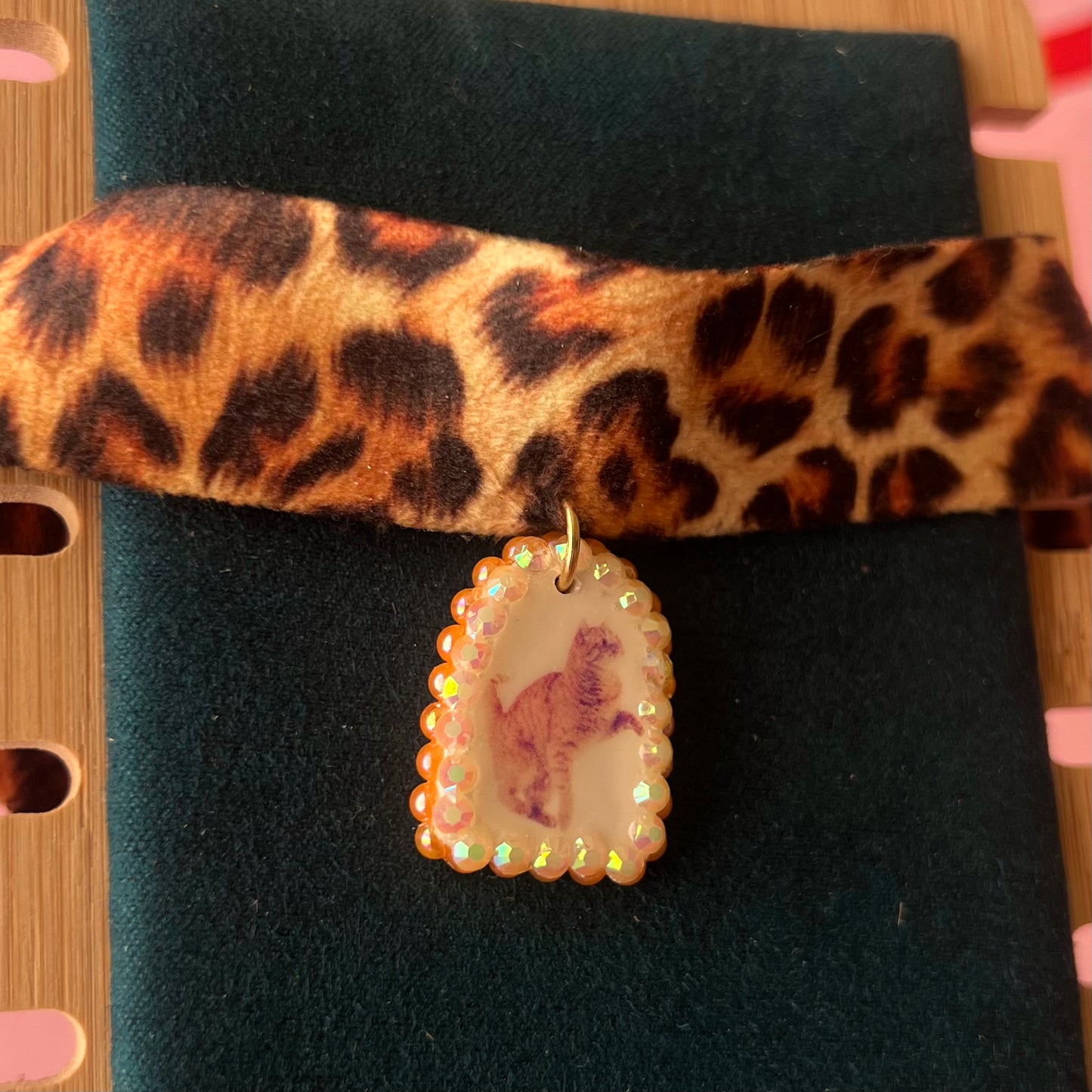 Orange cat charm choker — soft cheetah print choker with handmade polymer clay orange cat charm framed by bright orange pearls. Adjustable fit ~14–16" with extension chain. Gift-ready green Victorian-patterned box + bow. Y2K kitsch cat jewelry; ready to ship in 1–3 days.