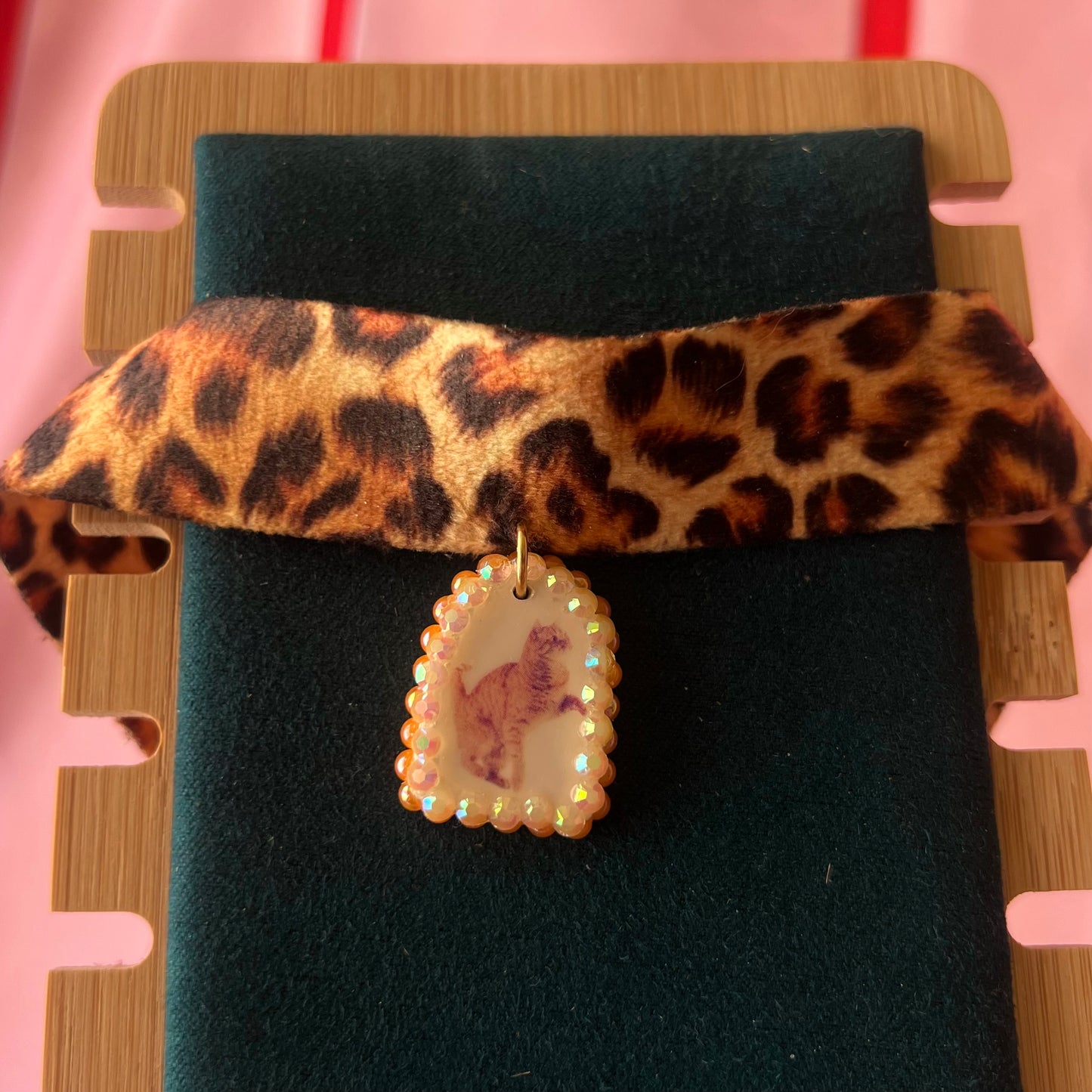Orange cat charm choker — soft cheetah print choker with handmade polymer clay orange cat charm framed by bright orange pearls. Adjustable fit ~14–16" with extension chain. Gift-ready green Victorian-patterned box + bow. Y2K kitsch cat jewelry; ready to ship in 1–3 days.