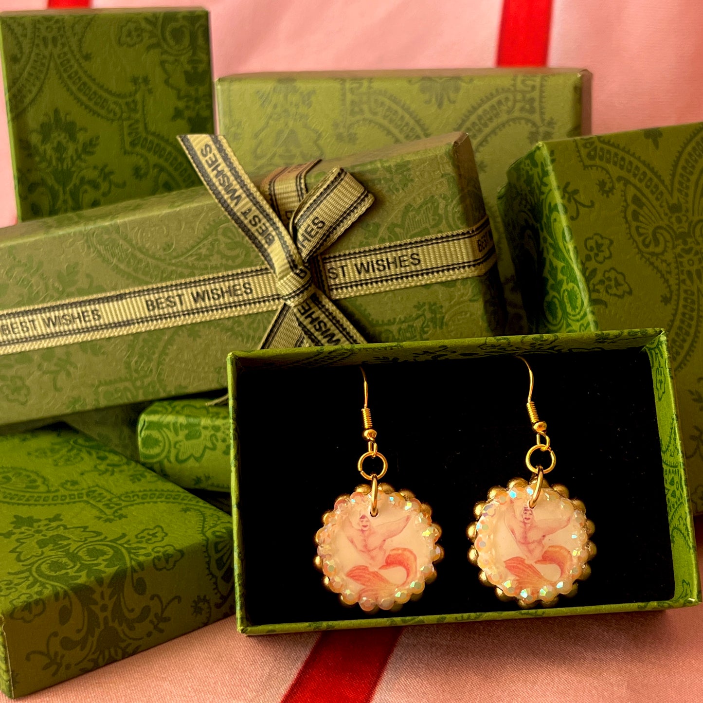 Handmade mermaid‑core earrings featuring a polymer‑clay merman portrait, bronze pearls, rhinestones, and 18k gold‑plated hypoallergenic findings—whimsical, nostalgic, wearable art perfect for a statement look.