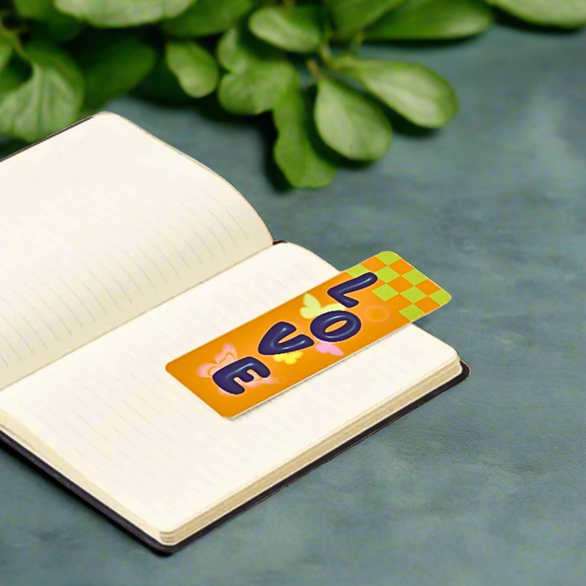 Open notebook with a colorful bookmark featuring the word 'love' on a green leafy background.
