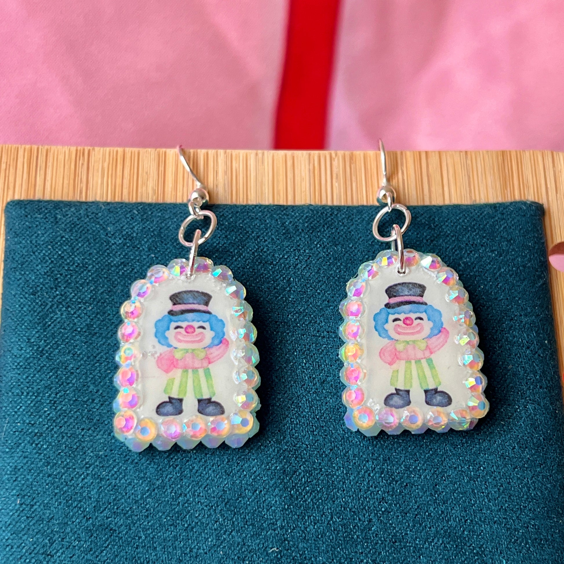 Alt text: Sparkly clown earrings—handmade polymer clay charms bedazzled with iridescent pearls and rhinestones, featuring silver‑plated hypoallergenic hooks. Perfect clowncore, kawaii, circuscore statement jewelry for festivals and alt fashion.