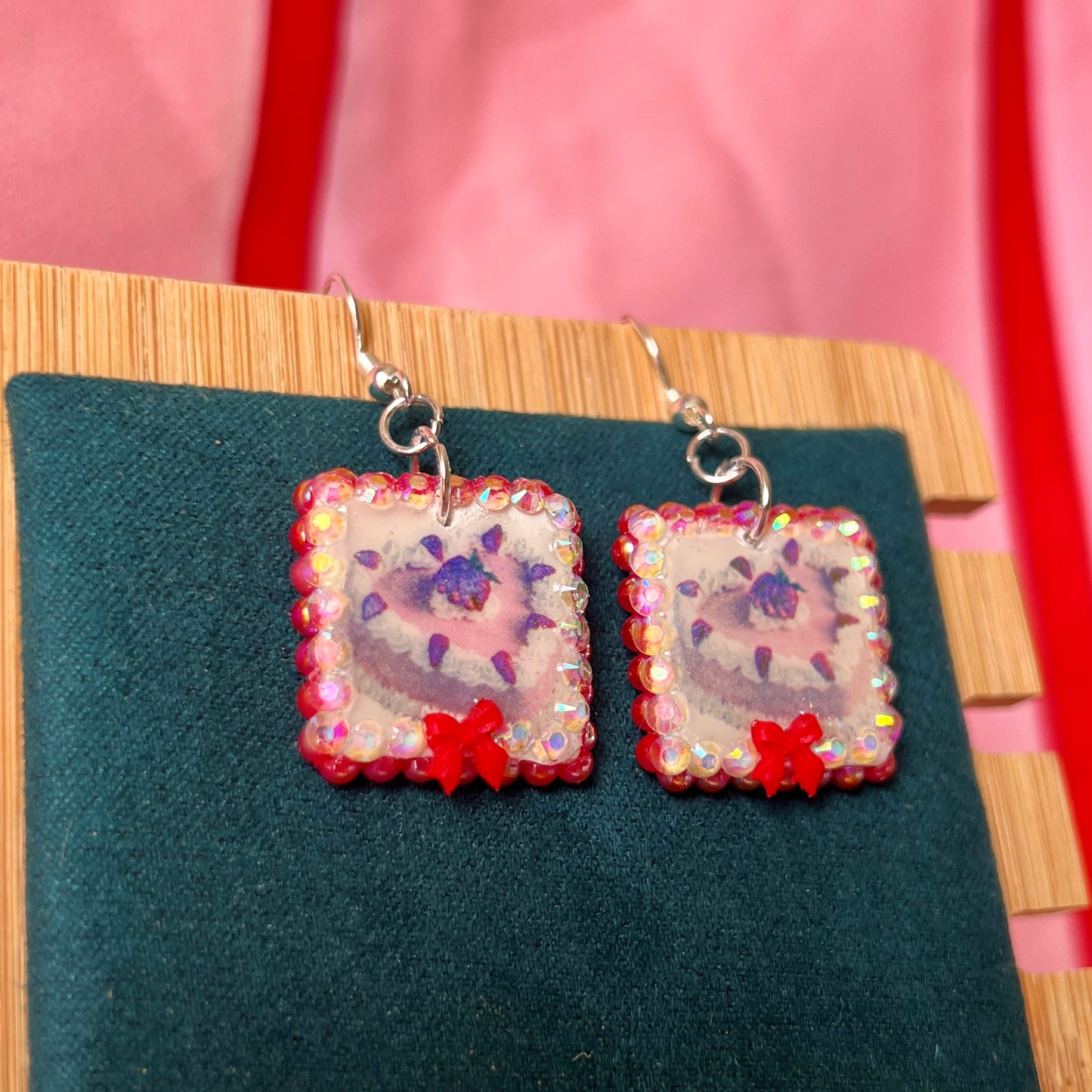Handmade strawberry cake and bow earrings — polymer‑clay charm, iridescent pearls, rhinestones, silver‑plated hypoallergenic hooks; sweet coquette, kawaii, pastel, Y2K dessert jewelry.