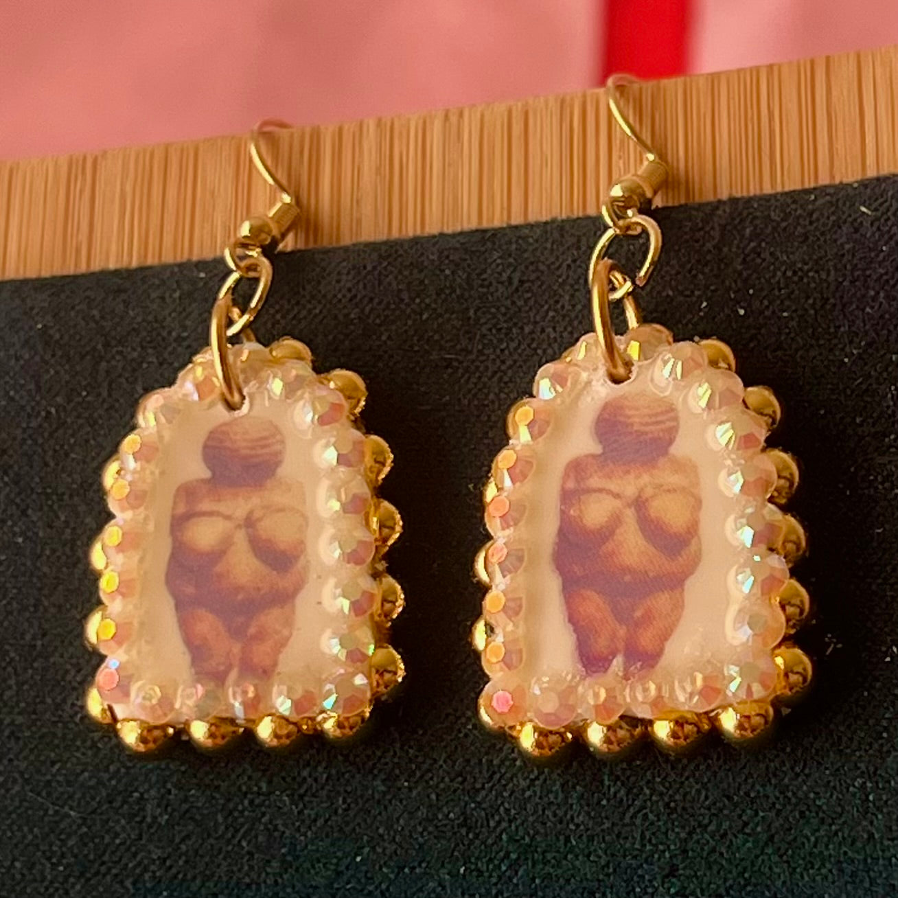 Handmade golden Venus of Willendorf portrait earrings featuring polymer‑clay image‑transfer arch charm (≈1 in), framed with metallic golden pearls and rhinestones, 18k gold‑plated hypoallergenic findings, museumcore/goddesscore art jewelry, gold statement earrings, wearable art, perfect gift for art lovers.