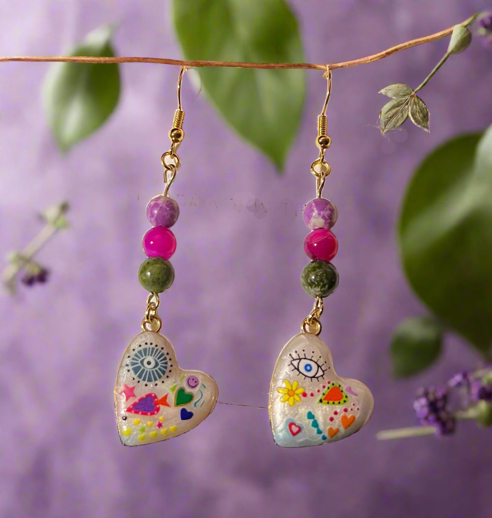 Heart-shaped earrings with colorful designs on a 'Handmade with Love' card.
