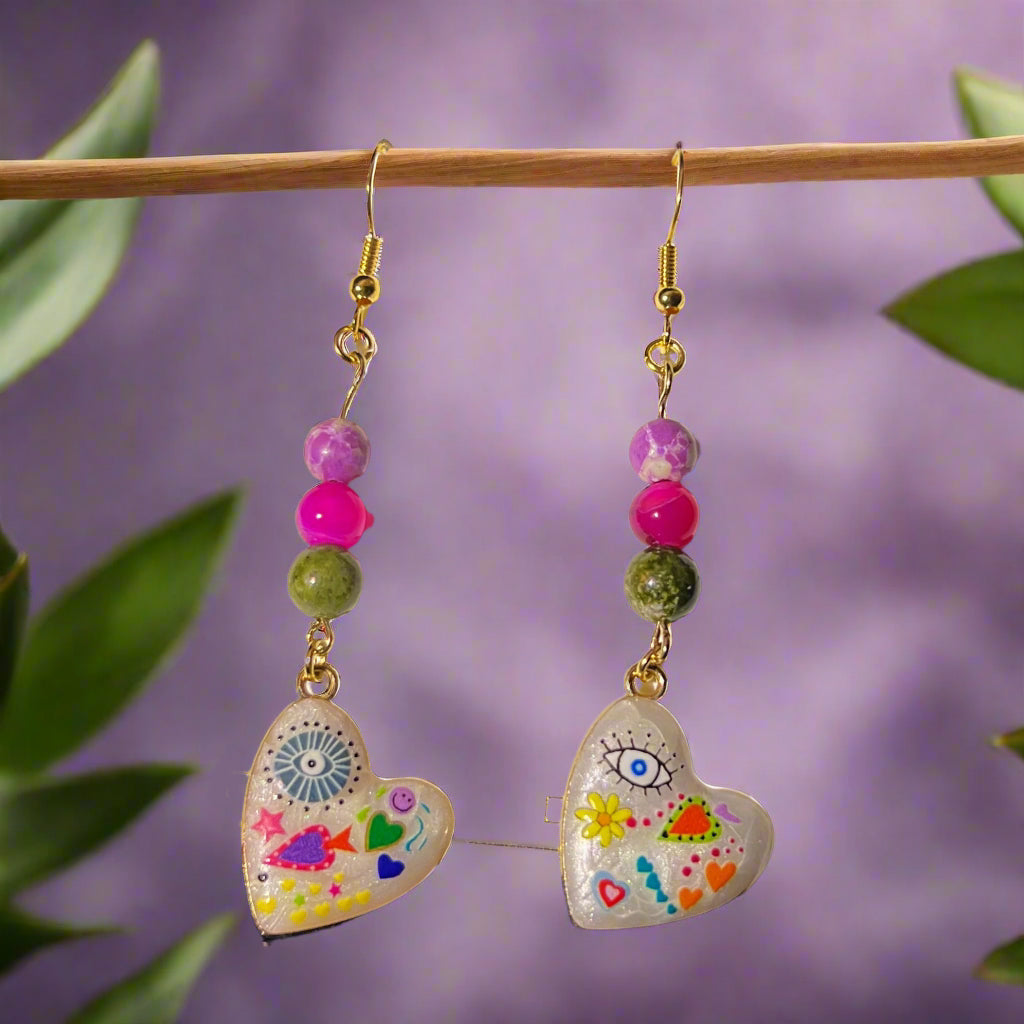 Heart-shaped earrings with colorful designs on a 'Handmade with Love' card.