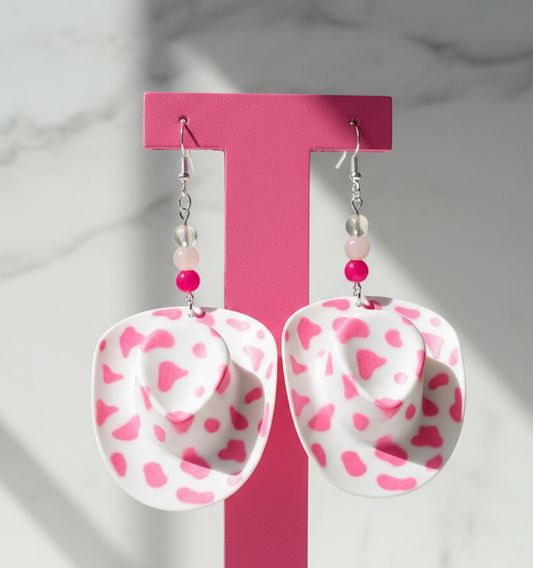 Cowboy hat-shaped earrings with pink heart patterns on a card labeled 'Handmade with Love'.