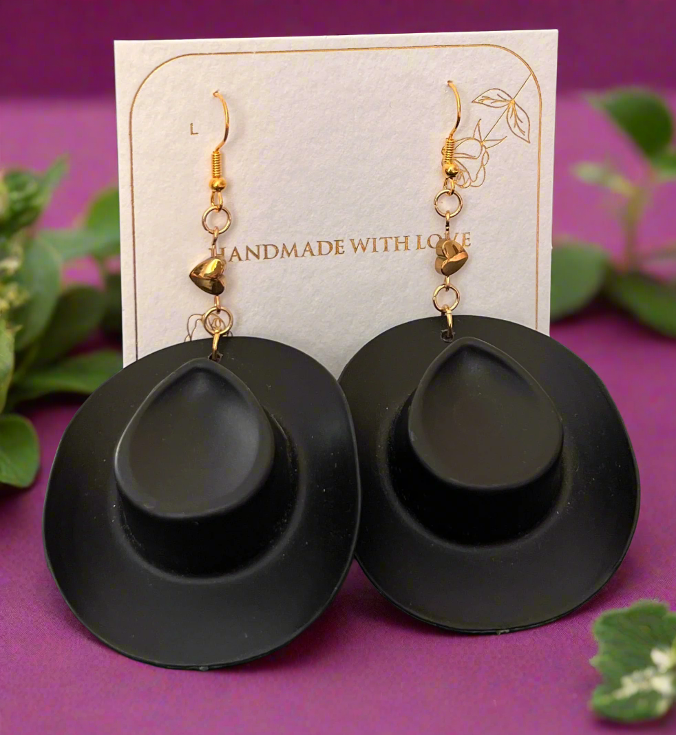 Black earrings with gold accents on a card that says 'Handmade with Love'.