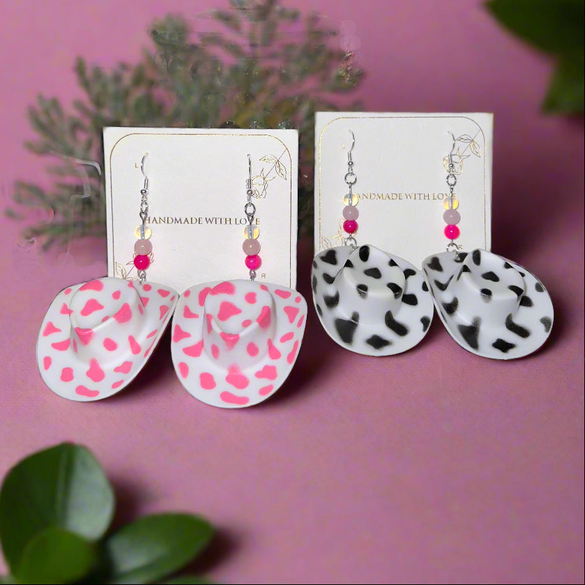 Heart-shaped earrings on display with packaging and a card in the background.