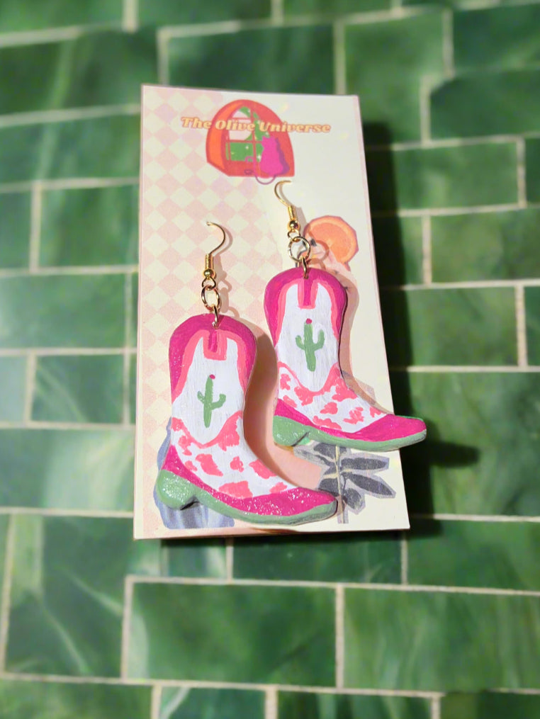 Cowboy boot earrings on a card with a green tiled background