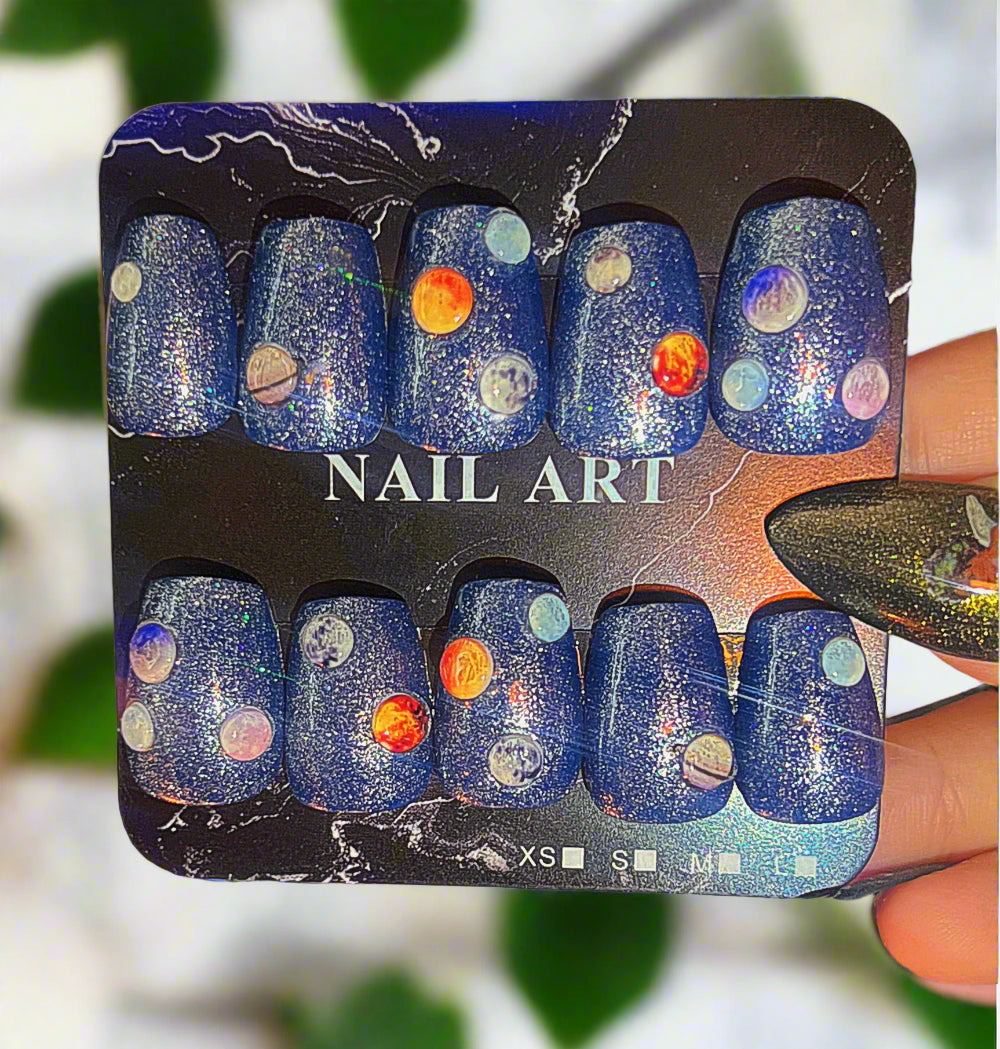 Nail art set with space-themed design on a black card