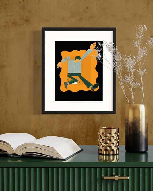 Framed artwork on a wall above a table with books and decorative items.