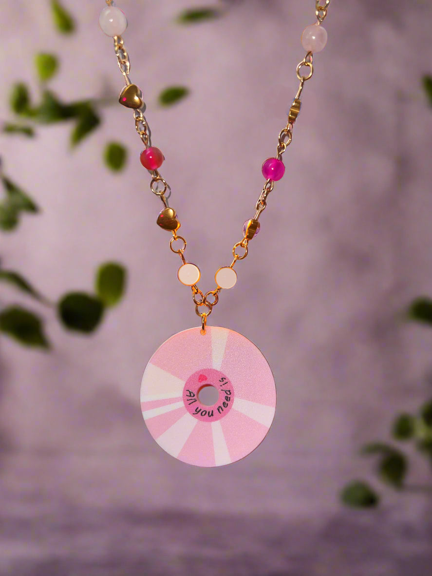 Pink and white decorative reel held by a hand with a blurred background