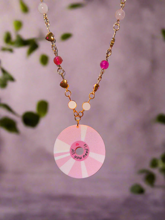 Pink and white decorative reel held by a hand with a blurred background