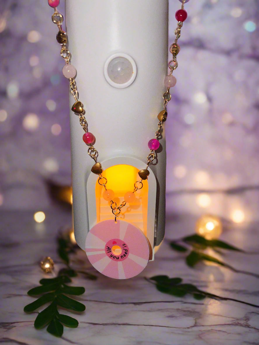 Necklace with pink pendant on a blurred background