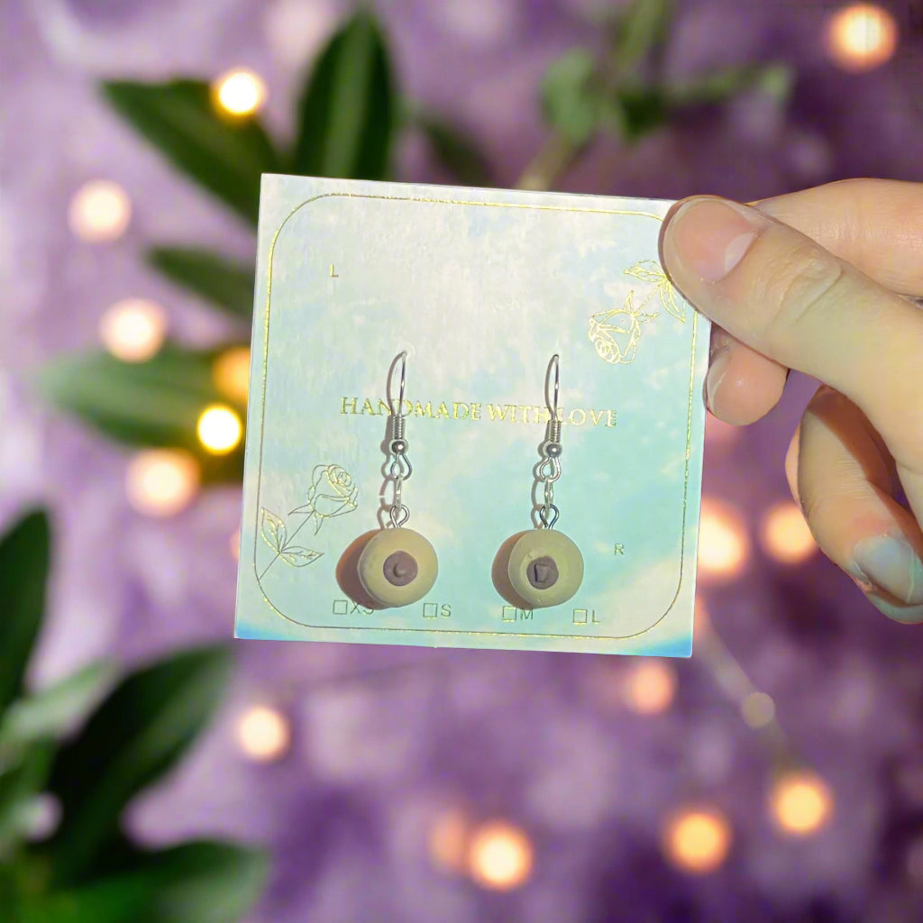 Person holding a card with earrings in front of a disco ball